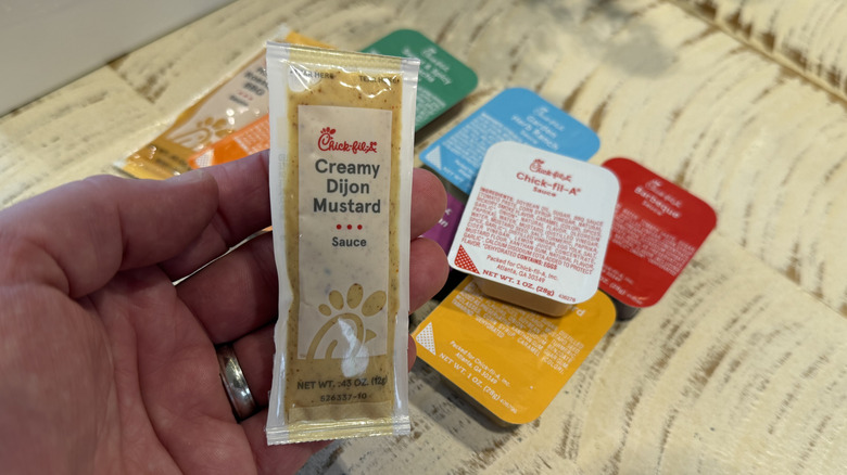 A packet of Creamy Dijon Mustard, above a pile of dipping sauces