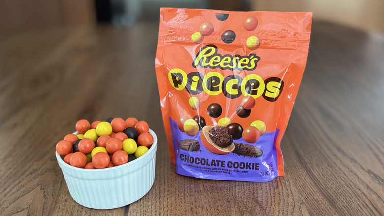 Pouch of new Reese's Pieces with chocolate cookies next to bowl of candies
