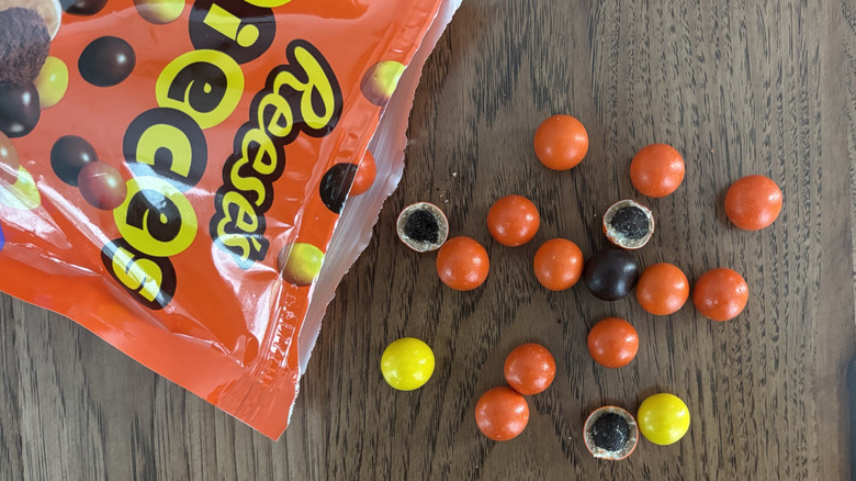 Reese's Pieces with cookie centers spilled on table from bag