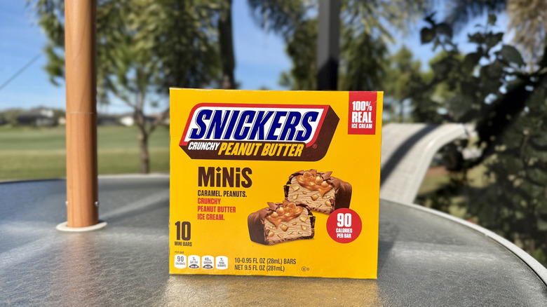 A box of Crunchy Peanut Butter Snickers Ice Cream Minis on an outdoor table