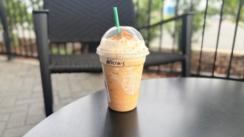 Horchata Frappuccino from Starbucks in a plastic to-go cup on a black table