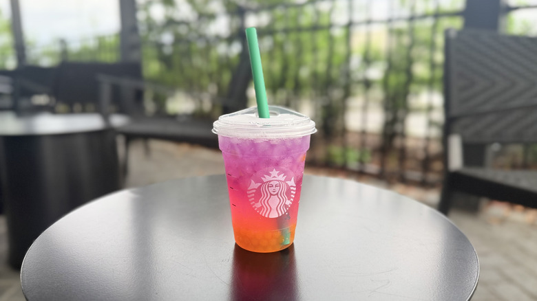 Tropical Butterfly Refresher from Starbucks in a plastic to-go cup on a black table
