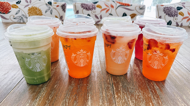 two rows of mango inspired drinks from Starbucks on a wooden table