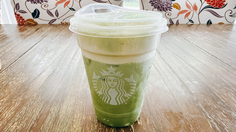 Starbucks iced mango cream matcha on a wooden table