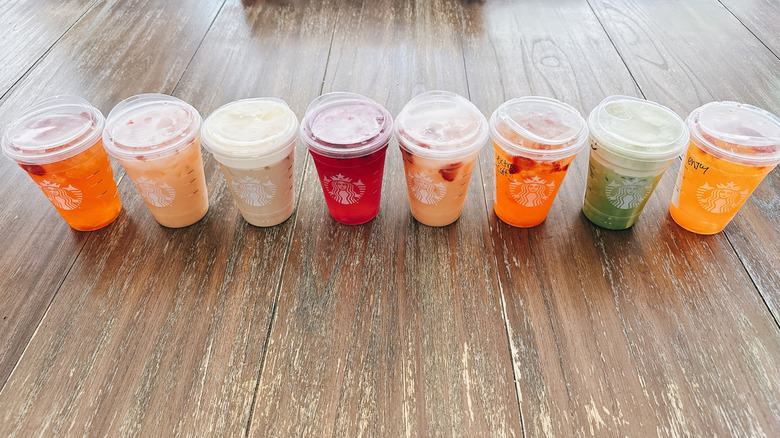 Eight Starbucks mango infused beverages on a wooden table