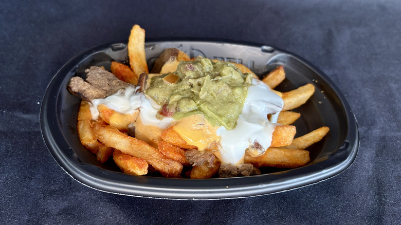 steak and guac nacho fries on black background