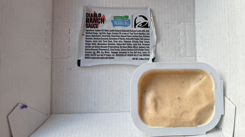 An open packet of Taco Bell's Hidden Valley Diablo Ranch Sauce with sauce visible