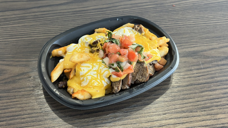 Taco Bell's Steak Garlic Nacho Fries in a black tray