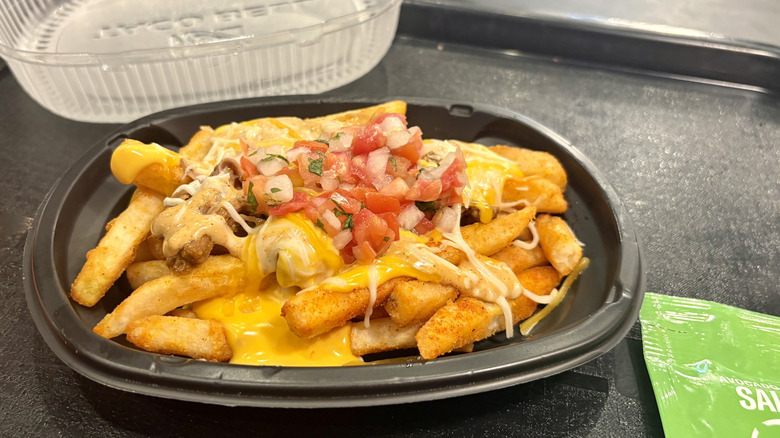 Shredded Beef Nacho Fries from Taco Bell on a tray next to some salsas