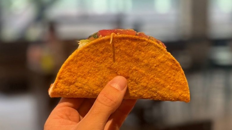 A hand holds a Tajín Taco from Taco Bell