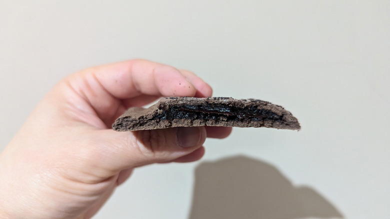 A hand holding a chocolate Pop-Tart Super Stuffed with a cross section.