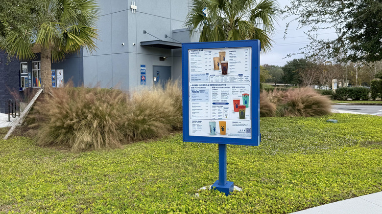 Dutch bros menu board in drive-thru in landscaped area outside coffee shop