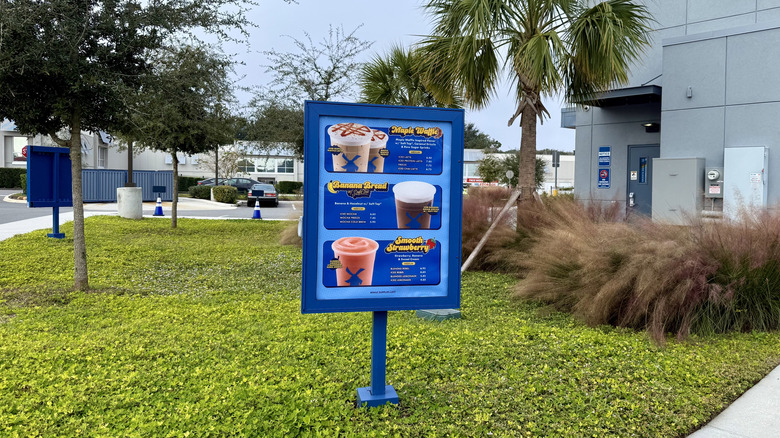 Dutch bros menu screen in landscaped lawn outside coffee shop featuring three new drinks
