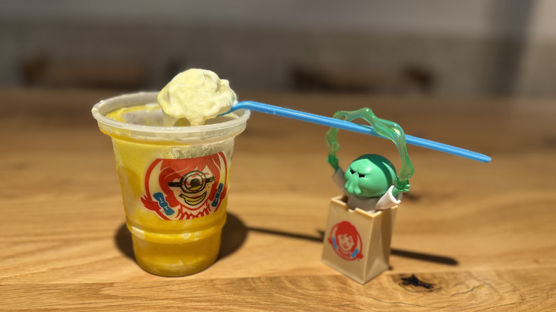 Goomi toy helps spoon up some of Wendy's x Minions Banana Frosty Swirl