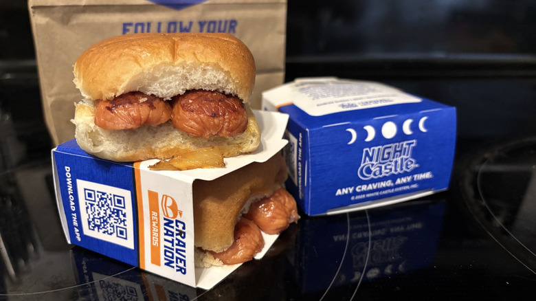 White Castle Cheddar Smoked Sausage Slider, boxes, and bag on black background.