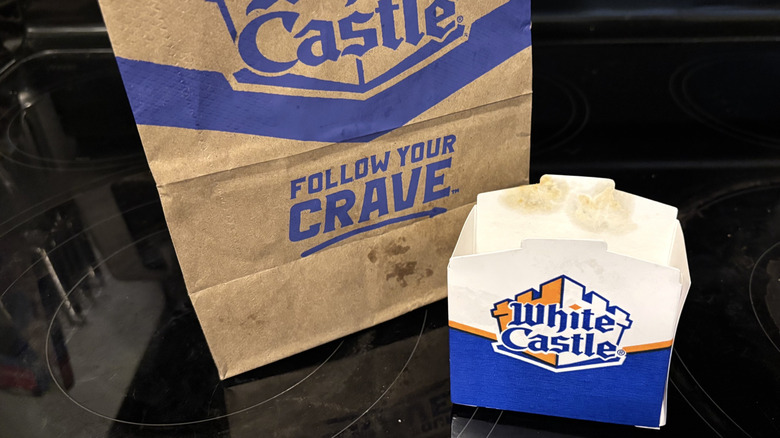 Empty White Castle box and bag on black background.