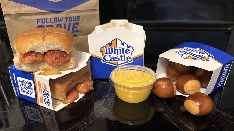 White Castle Cheddar Smoked Sausage Slider and Pretzel Nibblers in packages on black background.