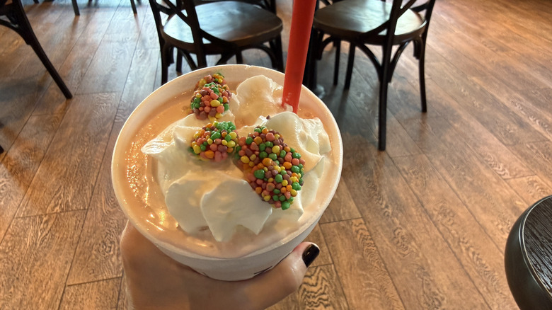 Top view of Zaxbys Strawberry Nerds Milkshake with straw, Nerds candy, and whipped cream