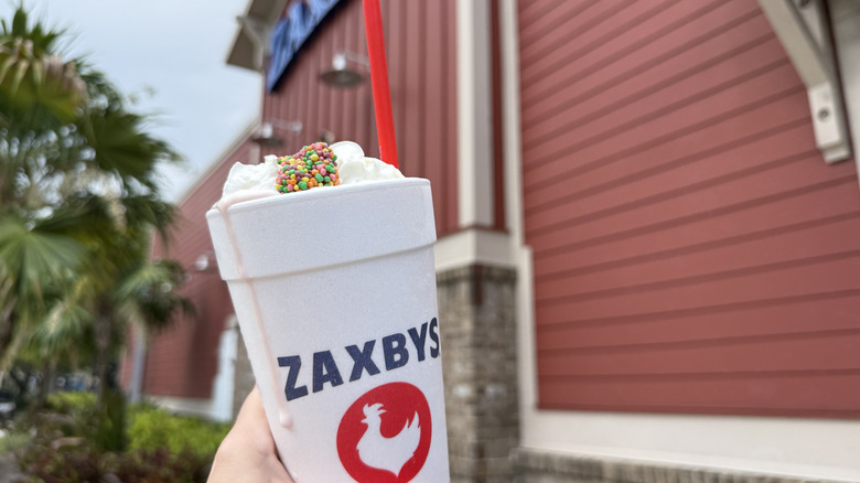 Zaxbys Nerds Strawberry milkshake in styrofoam takeout cup with straw outside restaurant