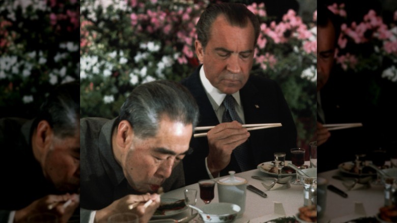 Richard Nixon using chopsticks while dining in China