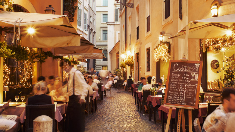 A street in Rome lined with restaurants and outdoor dining tables