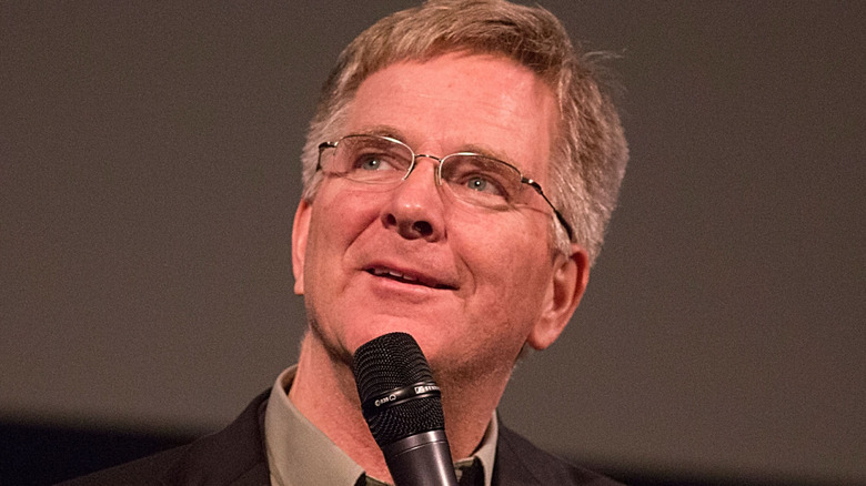 Rick Steves holds a microphone