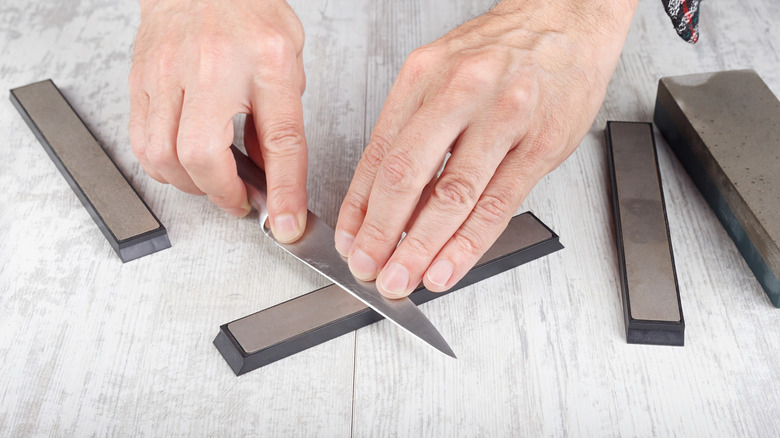Hands sharpening kitchen knife