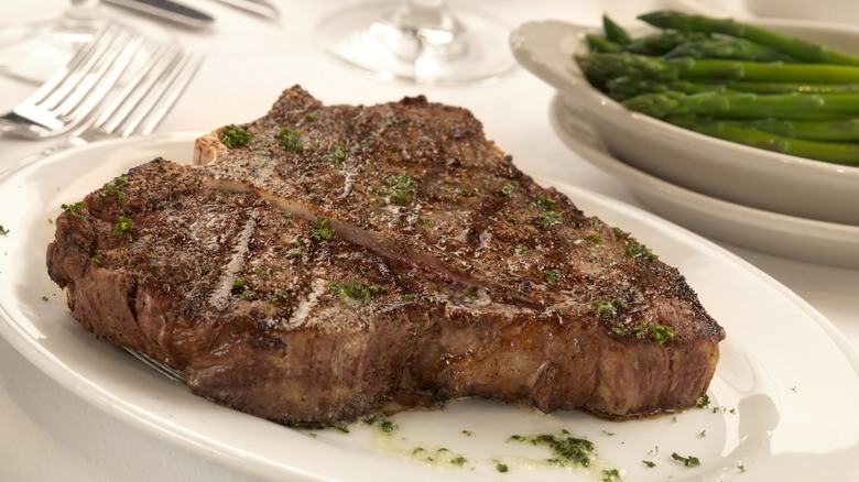 Porterhouse steak on a white plate.