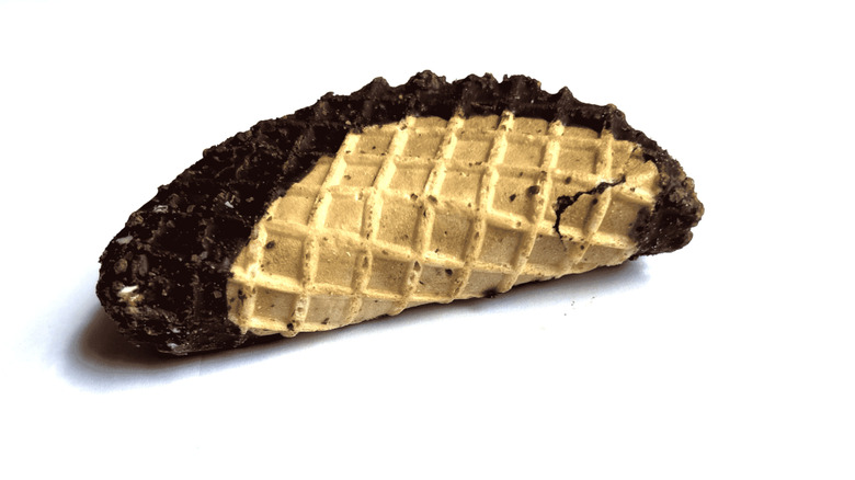 Hand holding a Churro Ice Cream Taco in its purple packaging