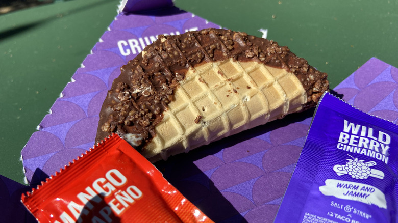 Tacolate in disassembled box beside sauce packets