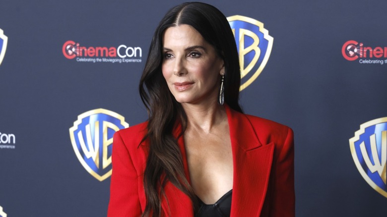 Sandra Bullock wearing a red blazer and looking off to the side