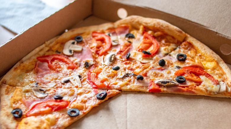 Leftover veggie pizza slices in a cardboard box