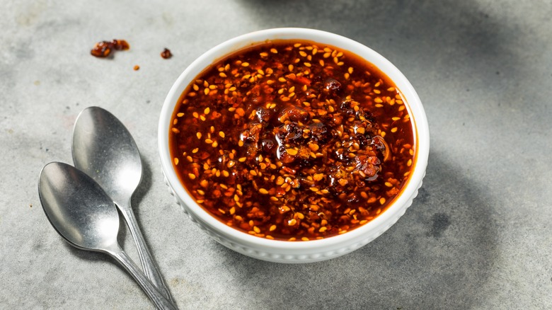 a bowl of chili crisp with two spoons on the side