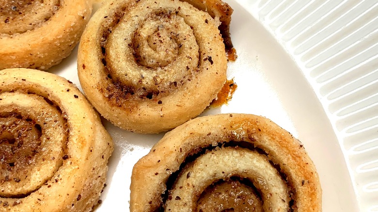 A close-up of cinnamon pinwheels on a white plate