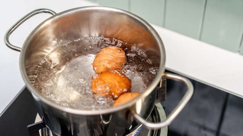 Eggs boiling in a pot of water on a stovetop