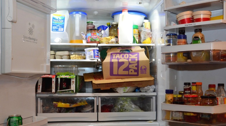 Disorganized fridge packed with food