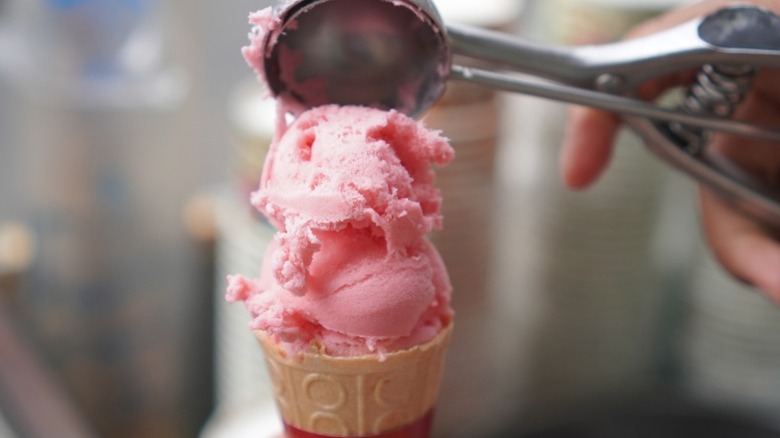 Assembly of a strawberry ice cream cone.