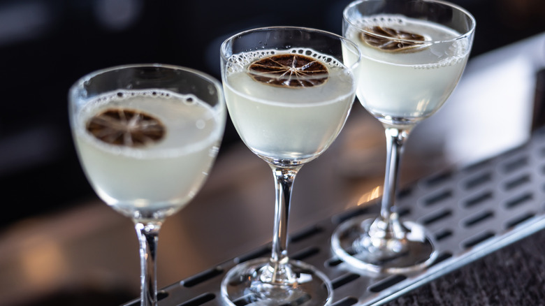 Three gimlets lined up at a bar