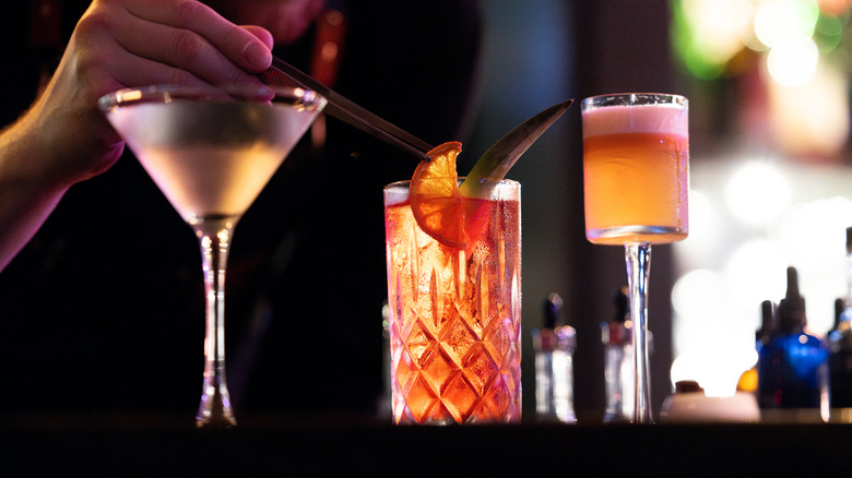 A bartender carefully crafting cocktails
