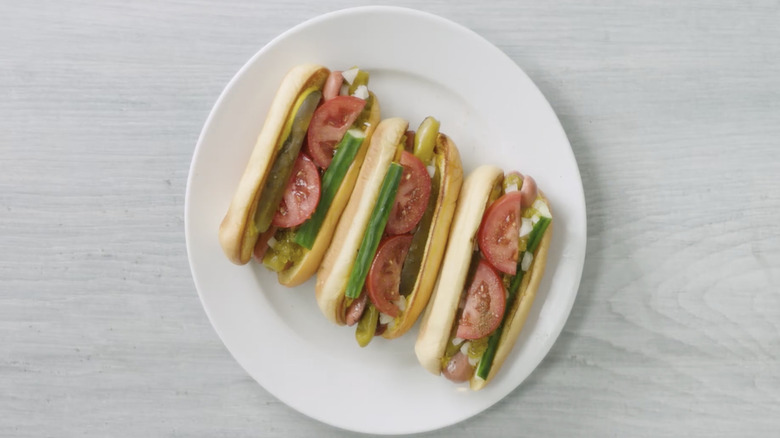 Screenshot of three Shake Shack Chicago-style hot dogs on white plate.