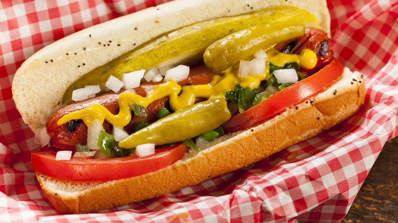 Chicago-style hot dog in boat with red checkered paper.