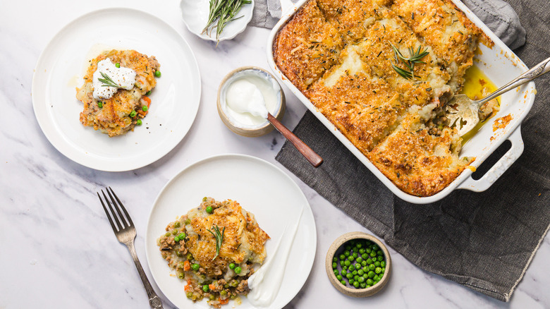 Shepherd's pie on table with napkins and two servings on plates