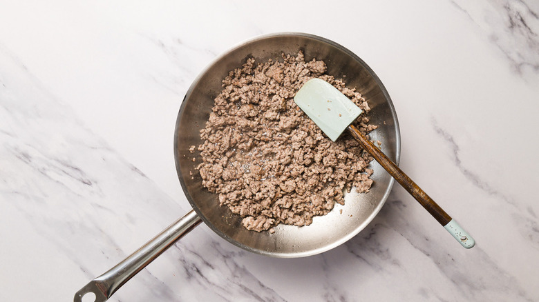 Cooked ground lamb in hot pan with oil