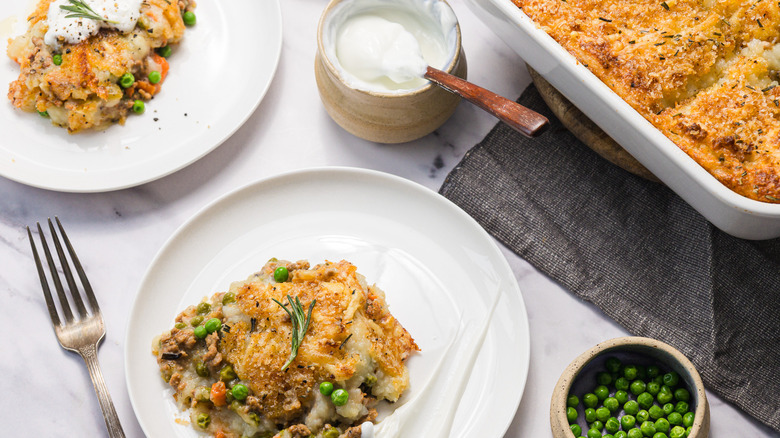 Shepherd's pie on table with napkins and two servings on plates
