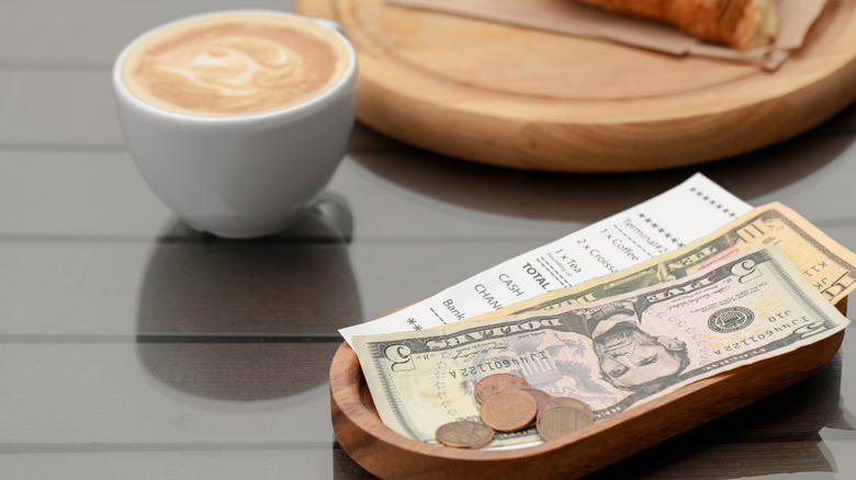 Cash tip and receipt with latte in teh background