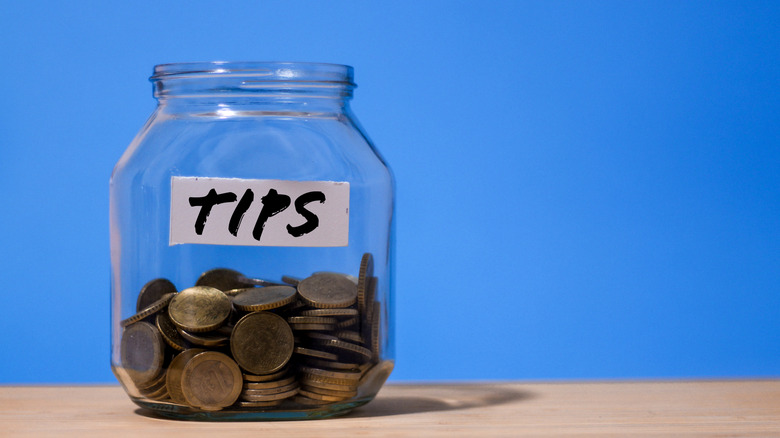 A jar one-third full of coins labelled "Tips"