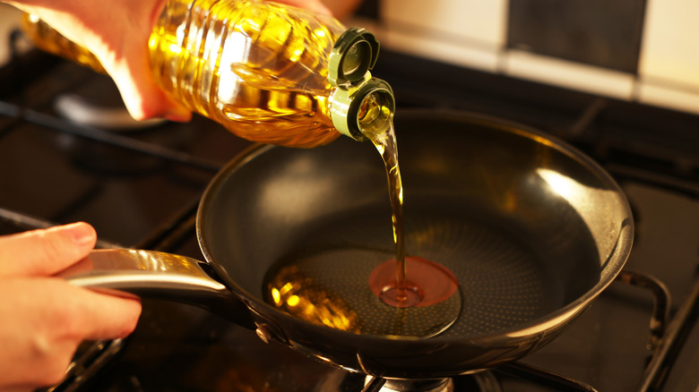Pouring oil into a pan on the stove