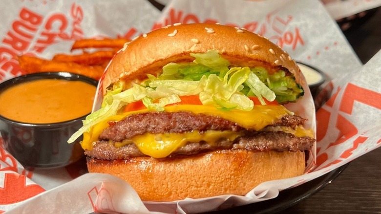 Close up of double tavern burger with fries and sauce in basket