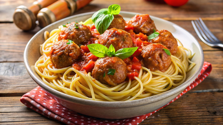 bowl of spaghetti and meatballs on a wooden table