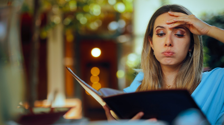 Confused woman looking at menu